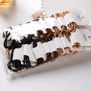 Detail view of knotted hair ties card pack, double strand rope design with metallic charms.