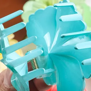 Blue flower hair claw clip detail close up, cute floral shark clip for women and girls daily wear.
