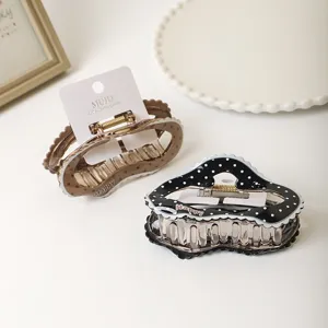 Detailed shot of sweet polka dot cloud hair claws with scalloped lace edges and metal spring.