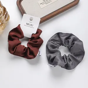 Set elegante scrunchies in tessuto marrone grigio con etichetta per donne e ragazze uso quotidiano.