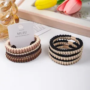 Detailed close-up of stylish pleated hair ties in brown and striped designs, carded set for daily wear.