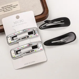 Close-up detail of silver PU leather geometric hair clips and classic black snap pins set.