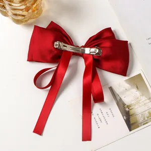 Red satin bow hair clip with elegant drape ribbons and metal spring clip for charming hairstyle