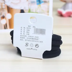 Detailed view of black nylon hair ties packaged on a white card with product specifications.