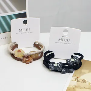 Detail shot of marble cloud pattern hair ties with resin flower and bow decorations.