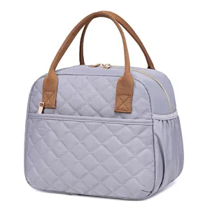 Quilted lunch bag detail view, insulated thermal tote with durable brown handles and front pocket.