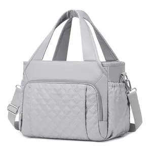 Grey quilted lunch bag for women with handles and shoulder strap, detail view of fabric.