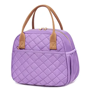 Quilted insulated lunch bag detail showing purple fabric, brown handles, and smooth zipper closure.
