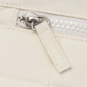 Detailed close-up of a white nylon quilted wallet zipper with metallic puller and tab.