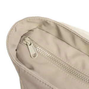 Gros plan détaillé sur la fermeture éclair et les coutures de ce sac cabas beige.
