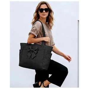 Detail view of the black bow tote bag showcasing lightweight fabric and shoulder straps.