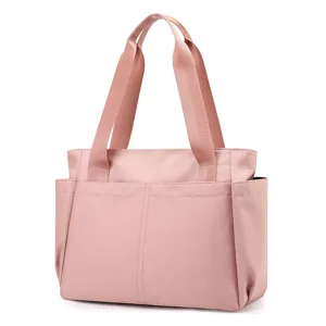 Pink canvas tote bag detail view, multi-pocket design, lightweight travel handbag for daily use.