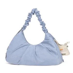 Detailed view of light blue gym hobo bag with scrunchie strap and separate shoe compartment.