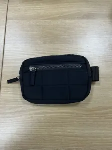 Black nylon quilted wallet detail showing zipper pockets and durable wristband design.