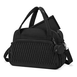 Black quilted diaper mommy bag with pacifier case and changing pad close-up detail view