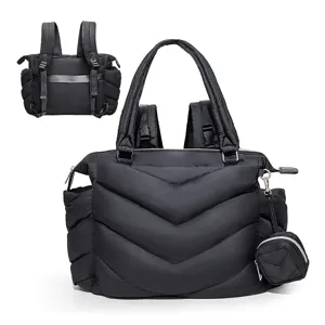 Detailansicht des schwarzen, gesteppten Wickelrucksacks mit Tasche und Henkeln.