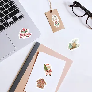 Vista dettagliata di simpatici adesivi natalizi mostrati su laptop e quaderni.