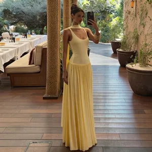 Yellow slim fit maxi dress featuring sleeveless bodice and pleated long skirt with strap.
