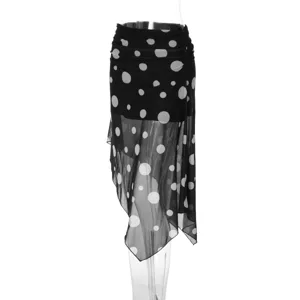 Detail view of black mesh polka dot skirt showing irregular hem and gathered waist.