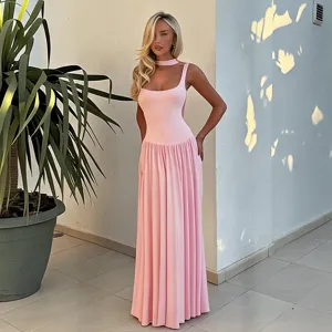 Detailed view of pink sleeveless maxi dress, fitted top and long pleated skirt style.