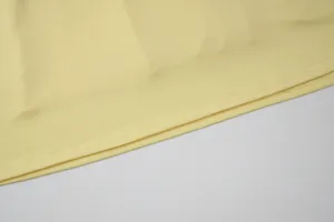 Yellow dress hem detail close up, premium fabric and fine stitching for women fashion