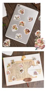Detail van vintage bloemboek stickers aangebracht op tablet en notitieboek oppervlak.