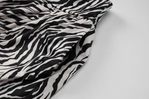 Gros plan d'une jupe a motif zèbre montrant la texture du tissu, plis et poches.