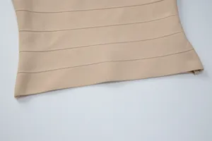 Λεπτομερής λήψη ενός κομψού μπεζ επάνω μέρους με ελαστική υφή οριζόντιου ριγέ υφάσματος.