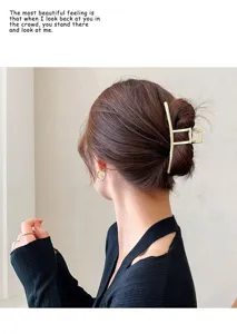 Detail shot of a sleek gold metal hair claw clip, elegant geometric design for chic updo hairstyles.