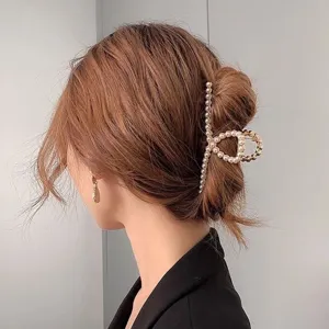 Elegant gold-tone metal pearl hair claw clip for women, stylish large shark clip back view.
