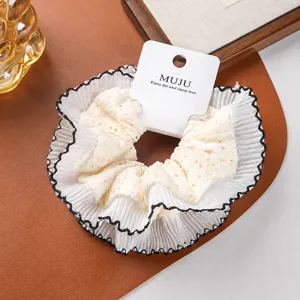 Detailed closeup of the oversized double layer lace hair scrunchie with chic black lettuce edge.