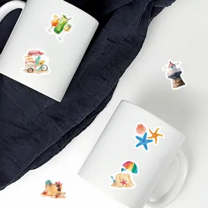 White ceramic coffee mugs decorated with cute watercolor beach and ocean theme stickers.