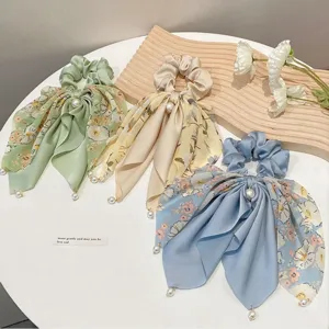 Elegant floral satin scrunchies with ribbon tails and pearl pendants for stylish hair styling.