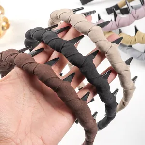 Primo piano dettagliato del cerchietto in tessuto ispessito con denti, consistenza morbida, colori.