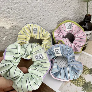 Sweet striped hair scrunchies with cute bear label, soft fabric pony tail holders detail shot.