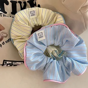Detail shot of cute striped hair scrunchies with sweet candy colors and lovely bear label.