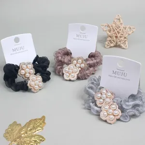 Detailed close-up of exquisite pearl flower mesh hair scrunchie with paper card packaging.