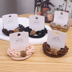 Detailed view of braided hair ties with rhinestone ball charms on cards. Perfect accessory.