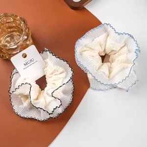 Detailed close-up view of large lace hair scrunchies with elegant black and blue edge stitching.