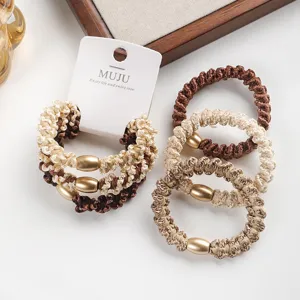 Close-up of Korean style carded brown hair ties with gold metallic beads, high elastic scrunchies.
