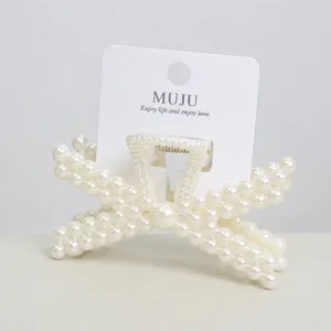 Detail shot of white faux pearl hair claw clip, elegant geometric woven design for women.
