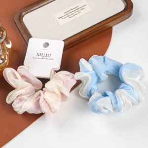 Close-up detail of gradient satin hair scrunchie, dual-color design, soft fabric texture.