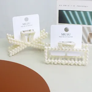 Detailed shot of sweet imitation pearl hair claw clips, elegant bow and rectangular styles.