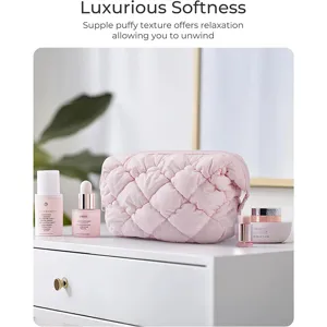 Puffy quilted cosmetic bag in soft pink, ideal for travel and daily organization needs.