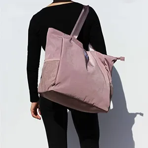 Vue détaillée du grand sac de sport rose avec poche filet latérale pour le fitness.