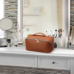 Detail shot of brown woven cosmetic bag, showcasing premium texture and practical handle.