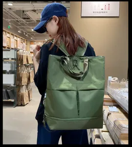 Sac à dos en nylon vert multi-poches avec poignées supérieures pour l'école et les voyages.