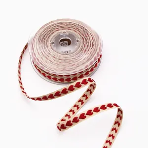 Yarn-dyed red heart embroidered beige fabric ribbon spool for wedding gift wrapping and DIY crafts.