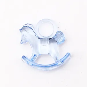 Detail close-up of clear blue acrylic rocking horse charm for DIY baby shower party craft decoration.