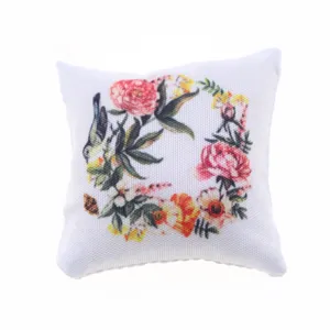 Gedetailleerde close-upweergave van het miniatuur poppenhuiskussen met bloemenprint.